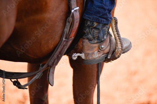 Horseman leg in boot at stirrup on horse during the riding