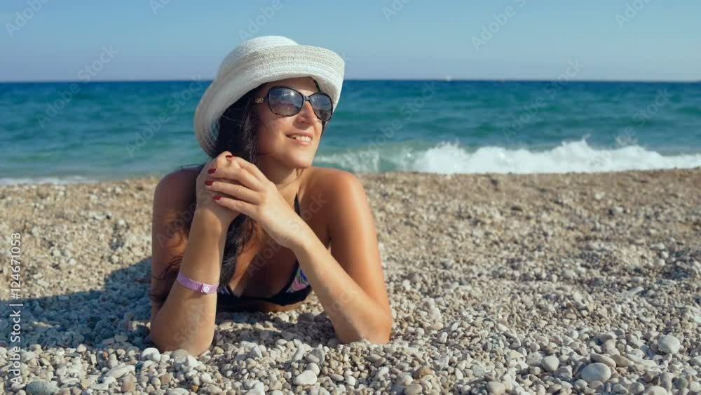 Smiling beautiful woman sunbathing on a beach Smiling beautiful woman sunbathing on a beach