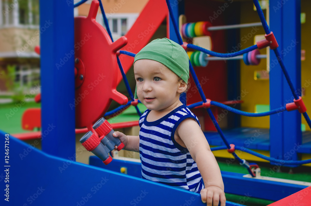 Little boy toddler playing on the playground in the form of a sh