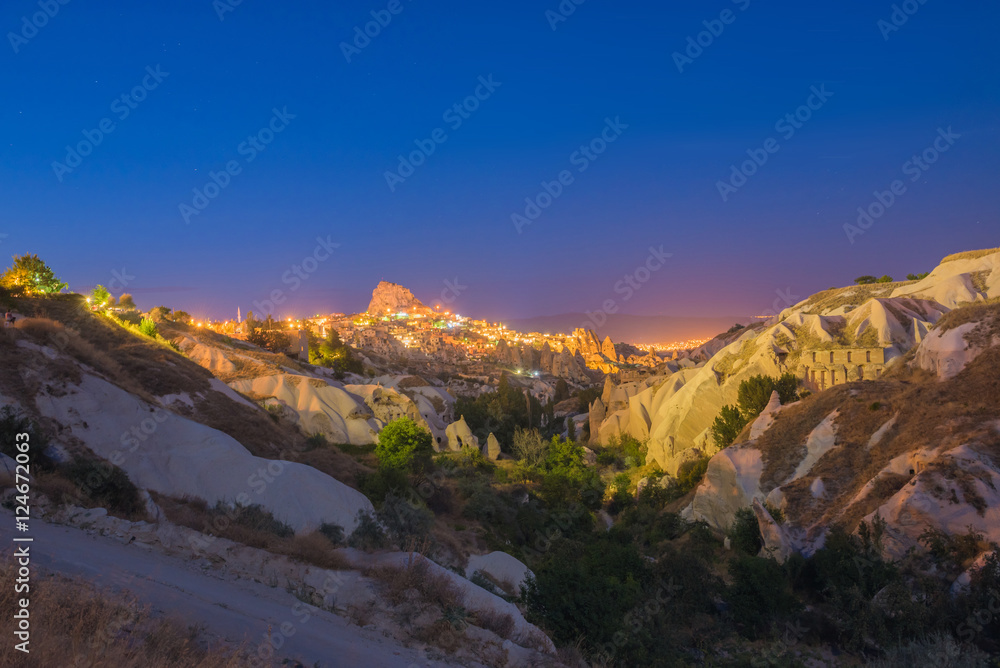 Ancient town and a castle of Uchisar dug from a mountains after twilight, Cappadocia, Turkey
