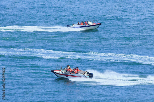 Speed boats passing each other in a blue sea
