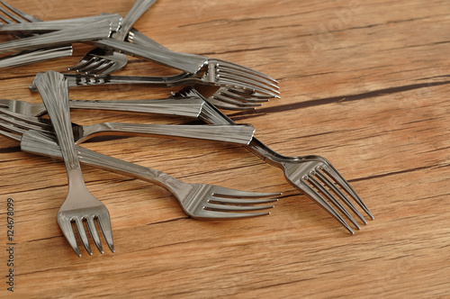 A pile of cake forks isolated on a wooden background