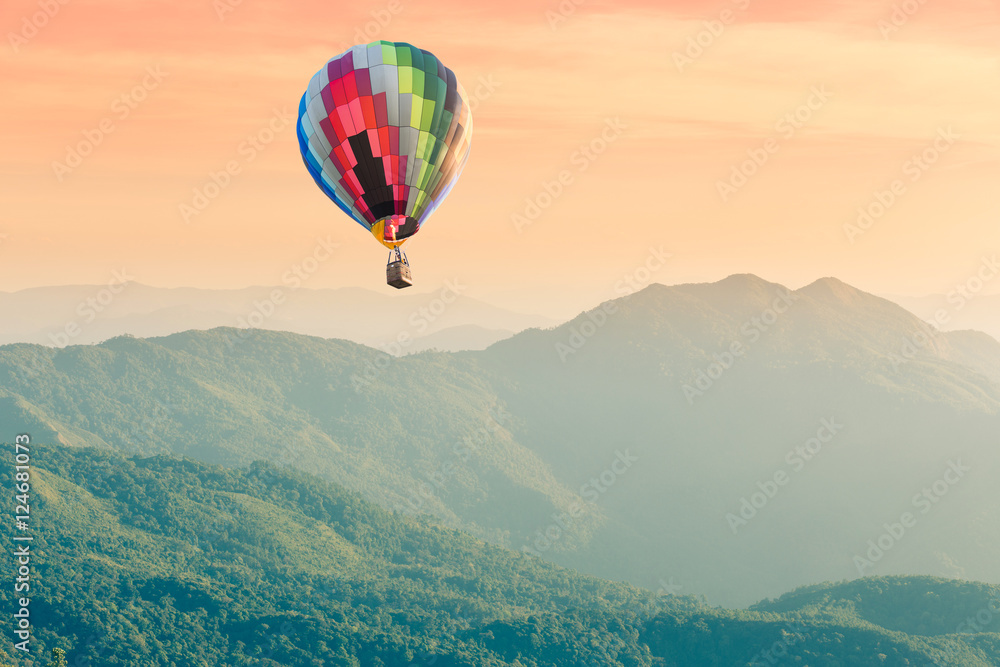 Hot air balloon above high mountain landscape at sunset Hot air balloon above high mountain landscape at sunset