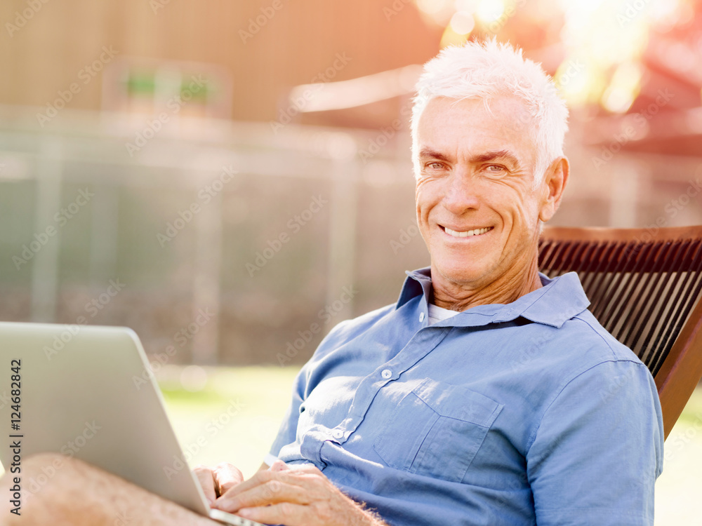 Senior man with notebook sitting in the park Senior man with notebook sitting in the park