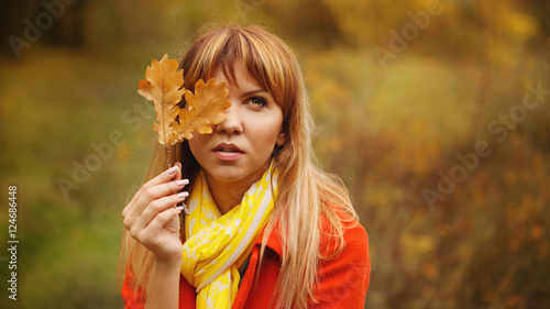 Woman hides her face behind the leaf