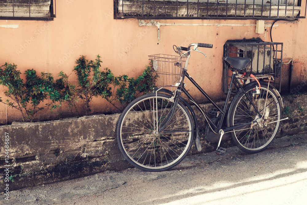 Φωτογραφία vintage bicycle parked at old wall in the urban narrow street (vintage color ton