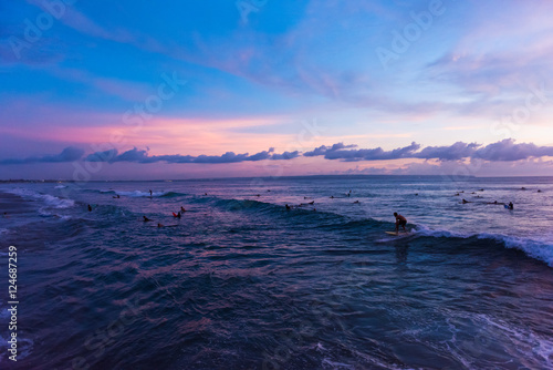 People surfing during sunset at Batu Bolong Beach in Canggu, Bali, Indonesia