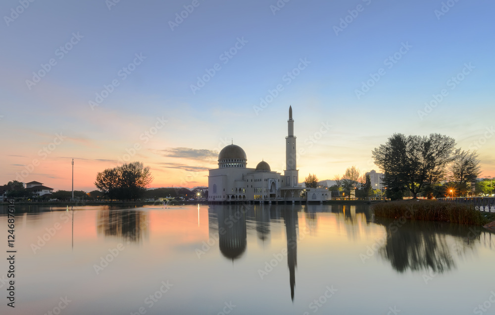 View and reflection of Assalam Mosque with blue skies and white clouds.