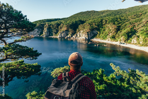 Male traveler from back on the sea coast