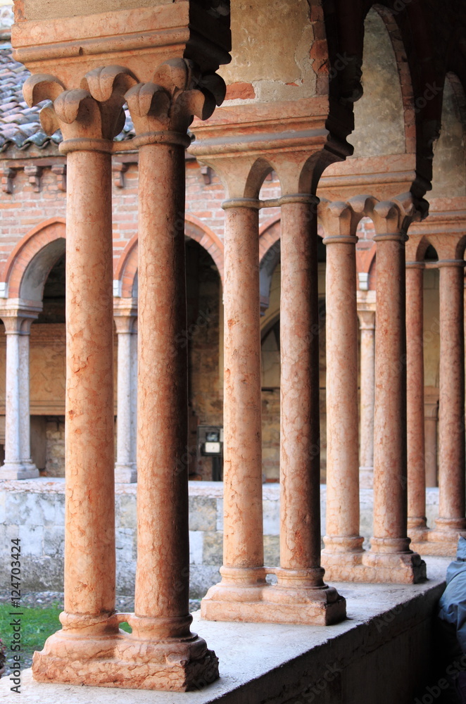 Columns and arches in the medieval cloister of Saint Zeno. Verona, Italy