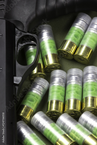 several bullet 12 gauge cartredges and shotgun trigger on green case