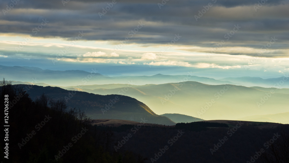 Fototapeta premium Rolling hills and mountains at autumn sunset, view from Bobija mountain, west Serbia