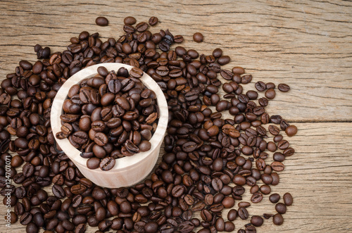Coffee beans set up on wooden cask and rustic background