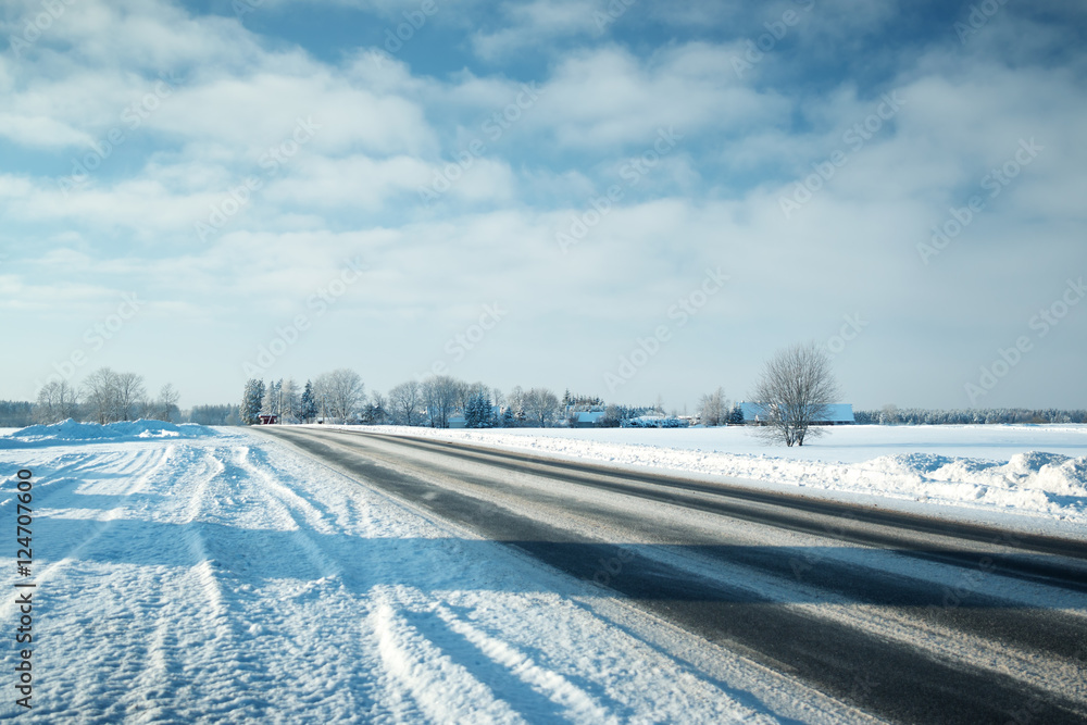 Asphalt road in snowy winter on beautiful frosty sunny day