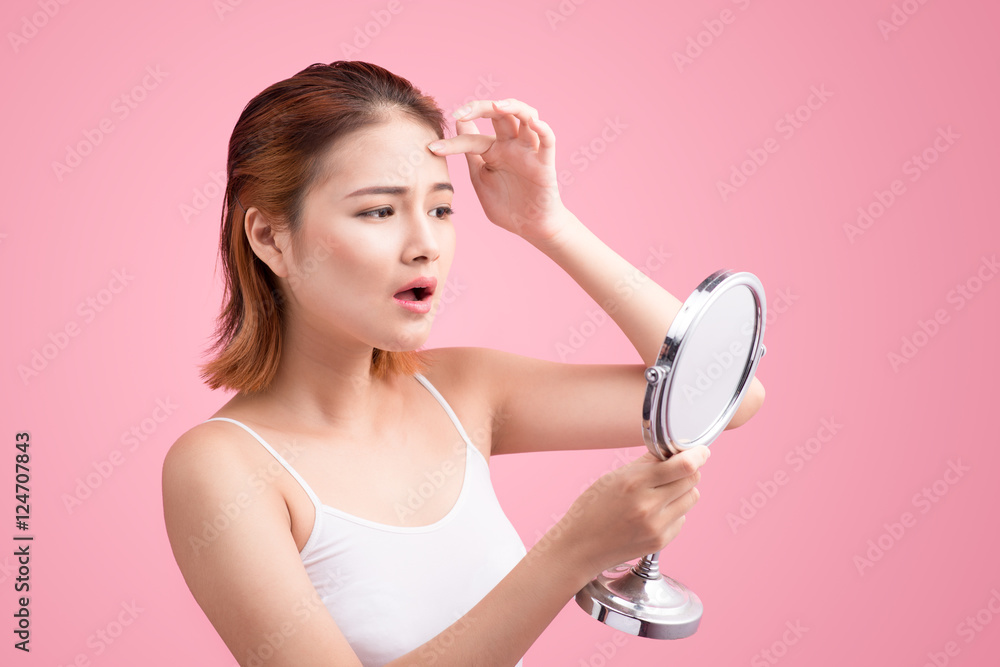 Pretty young asian woman holding a mirror, touch and worrying ab Pretty young asian woman holding a mirror, touch and worrying ab