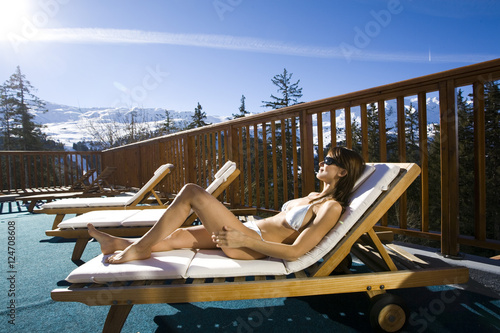 femme se relaxant au bord d'une piscine à la neige dans les montagnes  photo