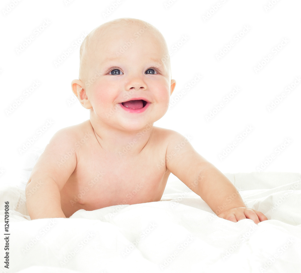 Beautiful smiling baby lying on his stomach in bed. One, isolate Beautiful smiling baby lying on his stomach in bed. One, isolate