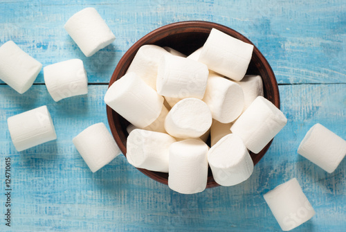 White marshmallow in  bowl on blue photo