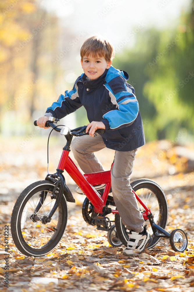 Happy boy with bicycle in the autumn park Happy boy with bicycle in the autumn park