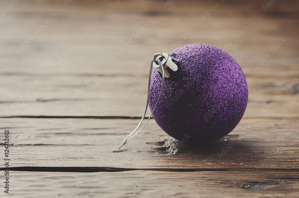Christmas card with purple ball on the wooden table