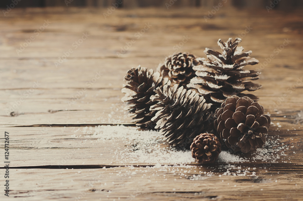 Christmas card with cones on the wooden table Christmas card with cones on the wooden table