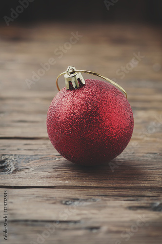 Red christmas ball on the wooden table