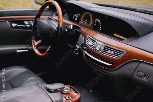 Dark luxury car Interior - steering wheel, shift lever and dashboard © kucheruk