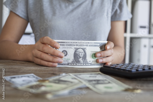 Close up of woman with calculator counting money 