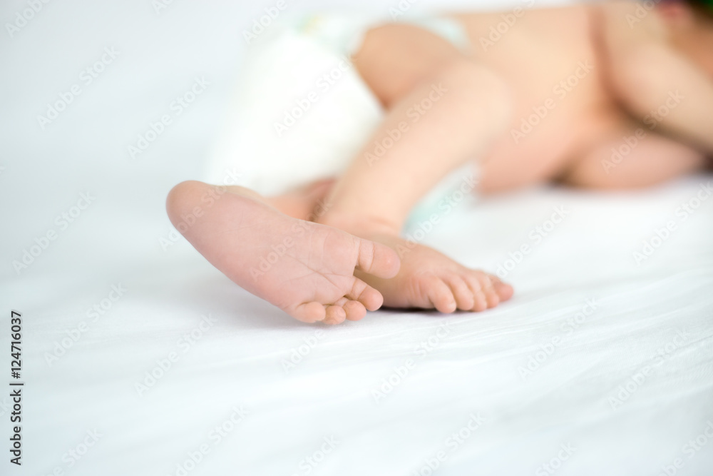 Close up of tiny sweet feet of sleeping newborn kid lying on white bed. Concept image Close up of tiny sweet feet of sleeping newborn kid lying on white bed. Concept image