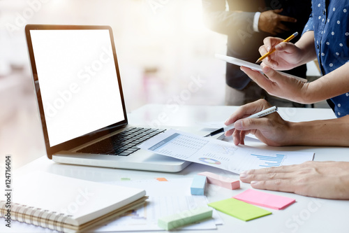 laptop with blank screen on table with business teamworks in modern office.Teamwork Concept.. photo