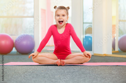 Cute little girl gymnast in gym. Sport, training, fitness concept