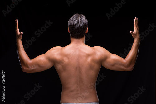 Ripped muscular man on black background