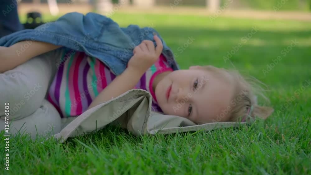Little girl resting on the grass. Little girl resting on the grass.