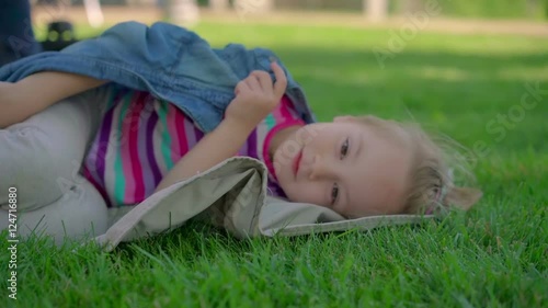 Little girl resting on the grass. photo