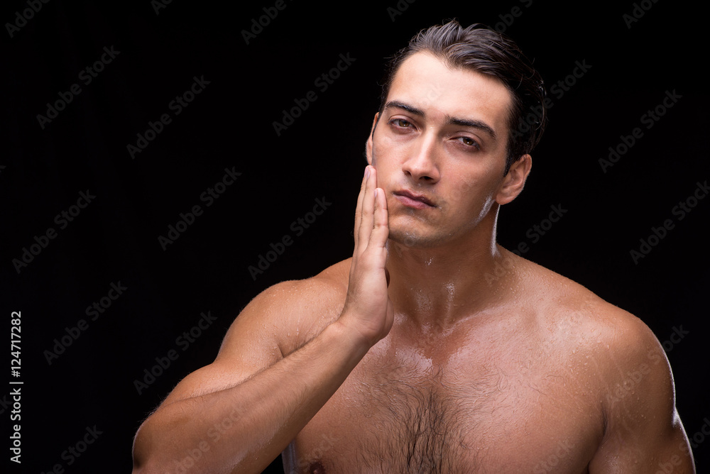 Man after taking shower on dark background Man after taking shower on dark background