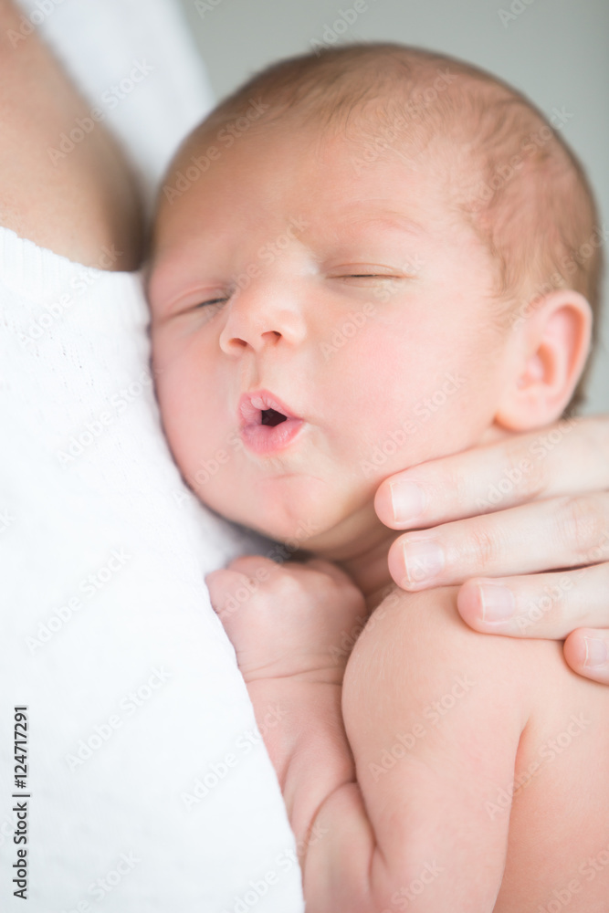 Portrait of a cute newborn hold at mother s breast, his mouth open. Family, healthy birth concept photo, close up Portrait of a cute newborn hold at mother s breast, his mouth open. Family, healthy birth concept photo, close up