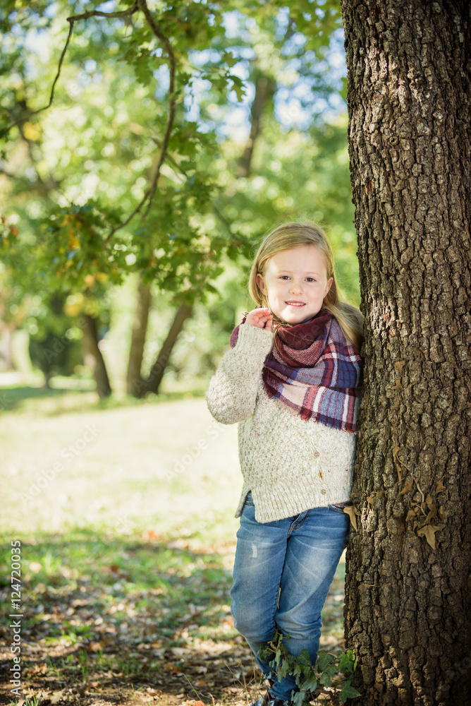 Unimaginably beautiful blond girl playing in the park hiding beh Unimaginably beautiful blond girl playing in the park hiding beh