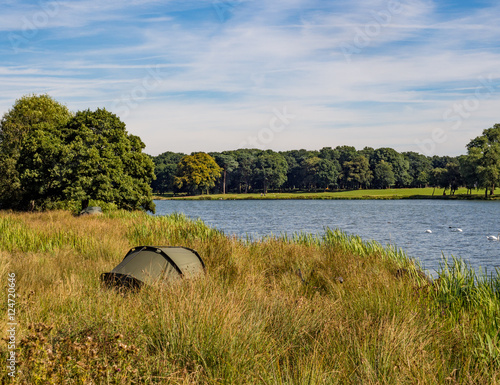 Fishermen sited on the edge of the water at Tatton Park, Knutsford, Cheshire, UK