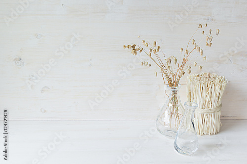 Soft home decor of  glass vase with spikelets and stalks on white wood background. Interior. © finepoints