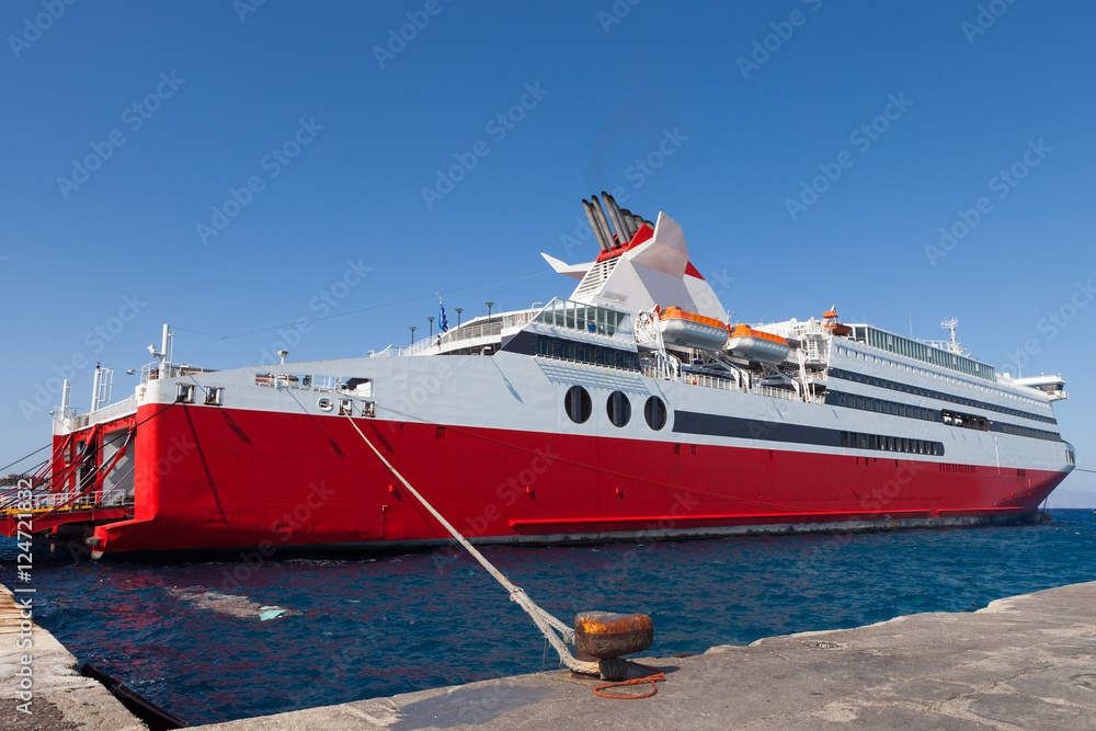 Naklejka premium Large red and white ferry docked at a port
