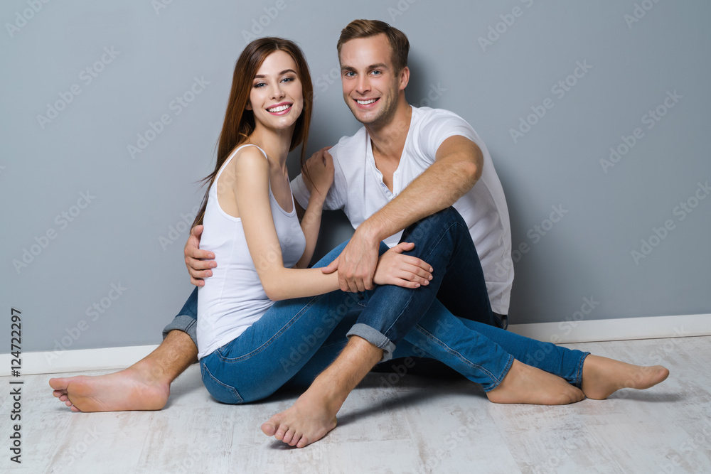 Beautiful young amorous couple, sitting on floor Beautiful young amorous couple, sitting on floor