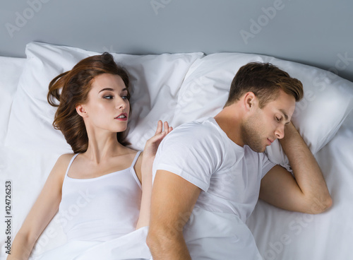 Unhappy young couple on the bed photo