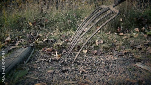 someone with pitchfork goes along old railway