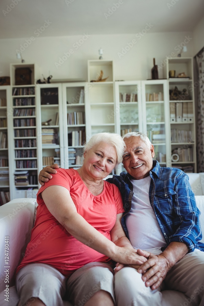 Portrait of senior couple sitting together on sofa