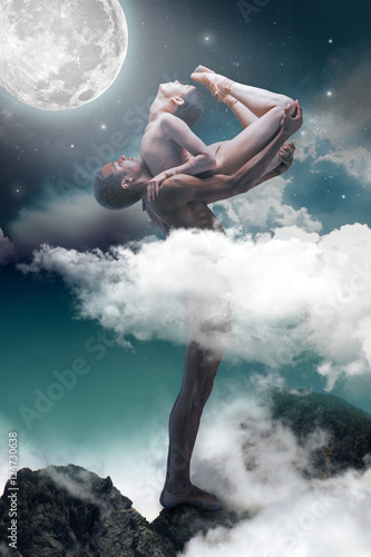 Couple of ballet dancers posing over gray fantasy background