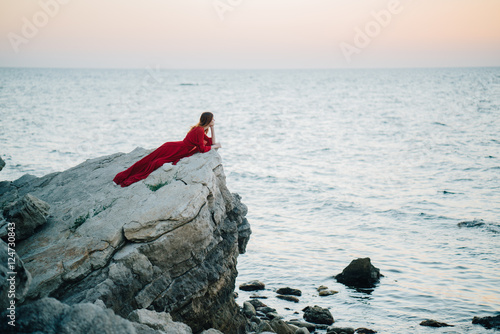 Woman on a rock in a red dress 
