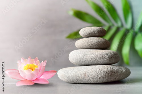 Spa stones with flower lily on light background