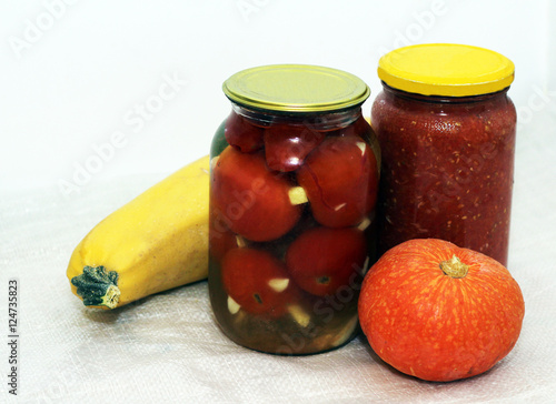 Homemade pickled tomatoes in jar and pumpkin photo