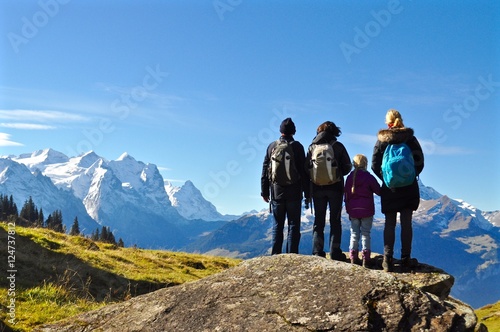 Wanderer - Familie,  stehen auf Felsen und geniessen den Blick und Aussicht auf die Schneeberge. Schneebedeckte Berge im Hintergrund, Schweiz