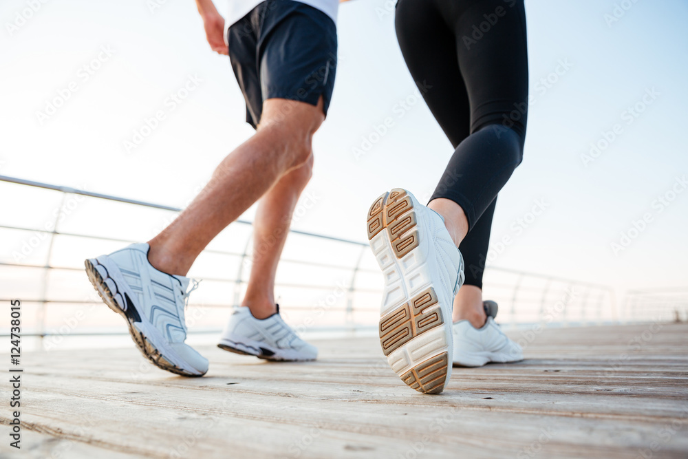 Cropped image of three runners sprinting outdoors Cropped image of three runners sprinting outdoors